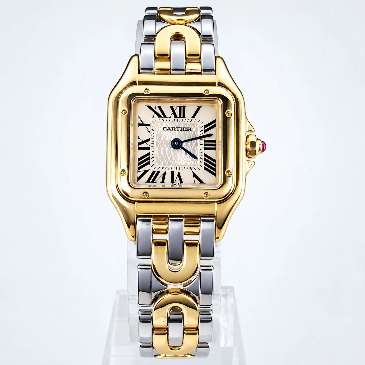 Cartier-Damenuhr in Stahl und Gold auf einem Glasständer