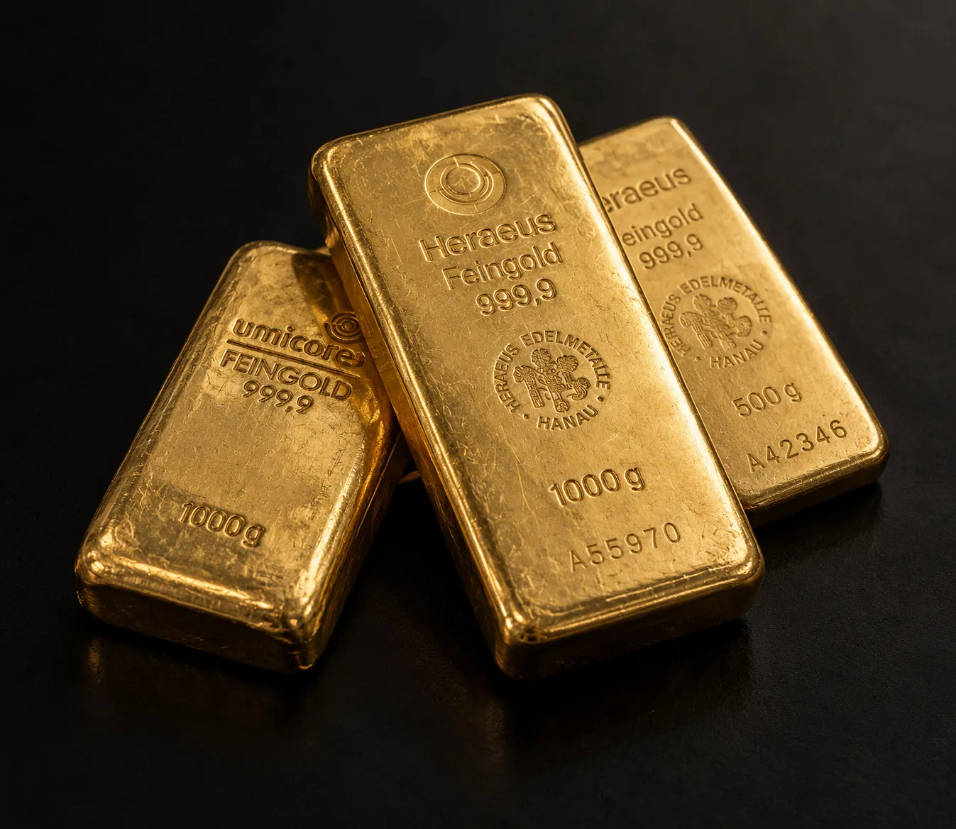 Goldbarren von Heraeus und Umicore mit Feingold-Prägung 999,9 auf dunklem Grund