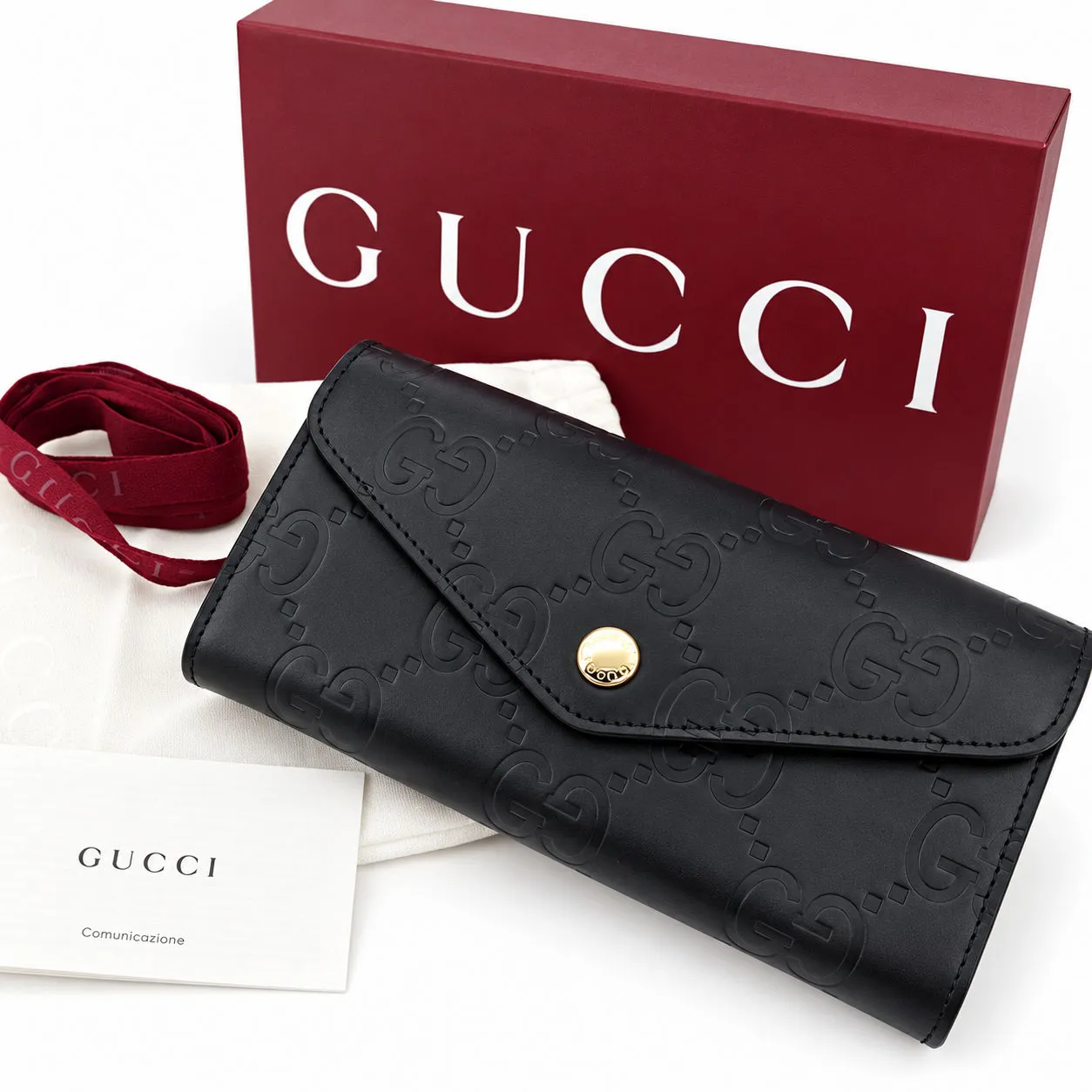 Schwarze Gucci-Geldbörse aus Leder vor einer roten Originalbox